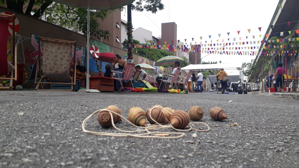 Imagem mostra peões jogados no chão e fundo de atrações na rua